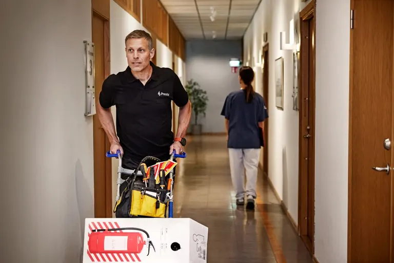 Presto-tekniker med værktøj og brandmateriel på et kundebesøg