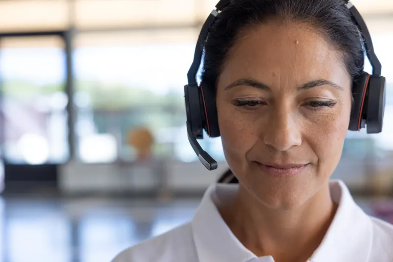 Medarbejder med headset ved sin arbejdsplads