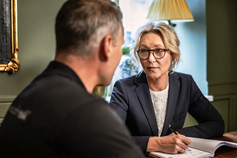 Presto-medarbejder og en kunde i samtale ved et bord